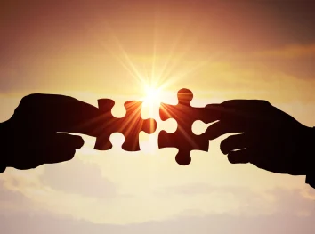 hands putting two jigsaw pieces together